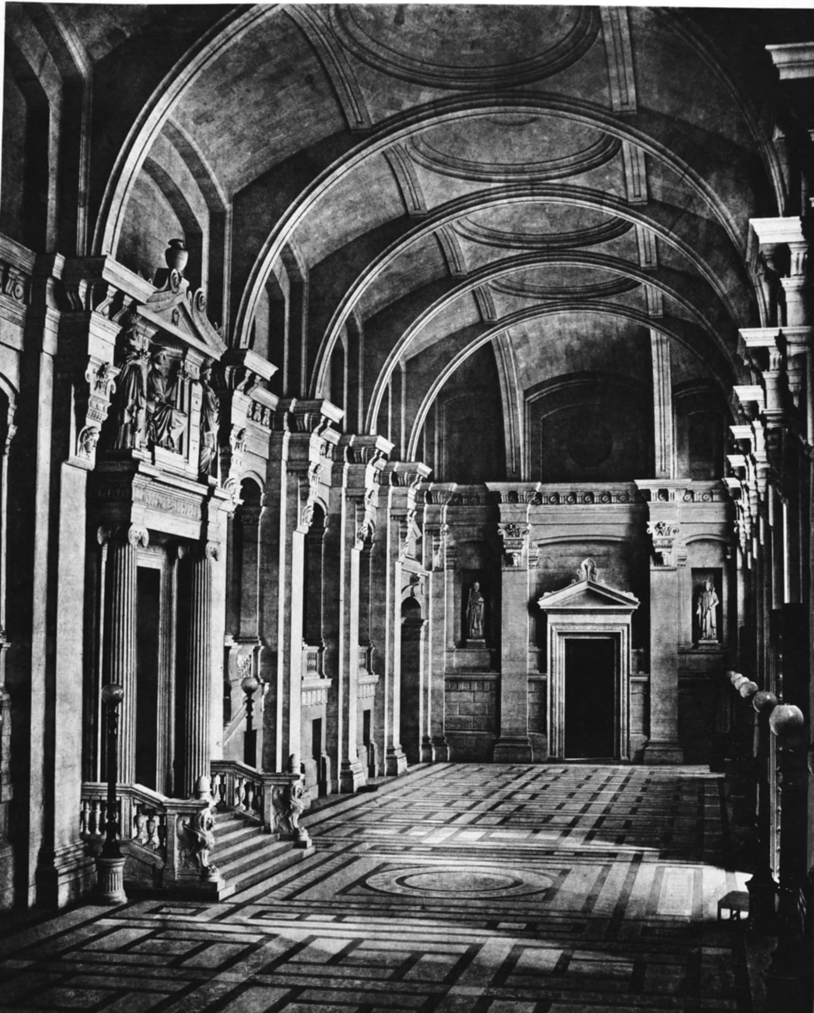 La salle des pas perdus du palais de Justice de Paris : une longue galerie voûtée, des colonnes et un sol dallé.